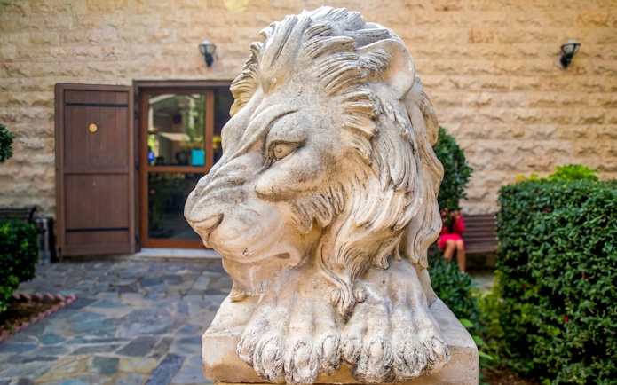 Stone lion statue at a winery entrance in Troodos Mountains, Cyprus.