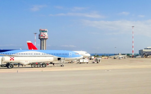 Palermo Airport runway with parked airplanes and control tower.