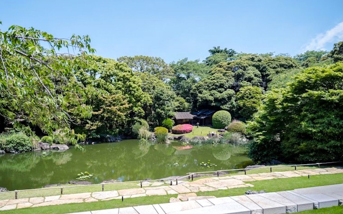 Tranquil garden with pond and lush greenery at Tokyo National Museum.