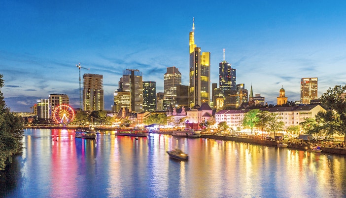 Frankfurt skyline at dusk with illuminated buildings and river during Evening Panorama Cruise.
