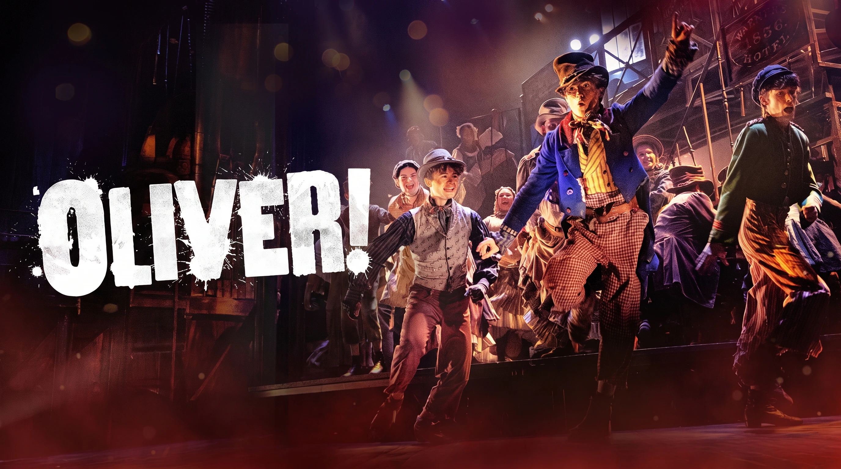 Performers dancing energetically on stage in the Oliver! show.