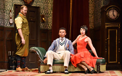Actors in a comedic scene from "The Play That Goes Wrong" on stage.