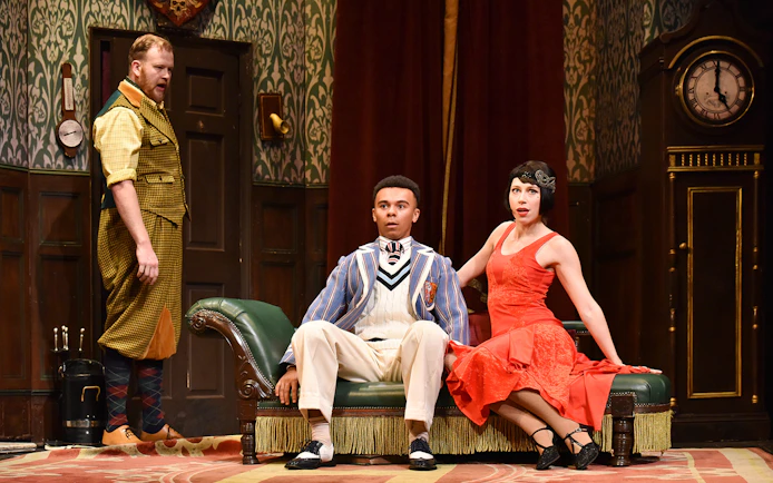 Actors in a comedic scene from "The Play That Goes Wrong" on stage.