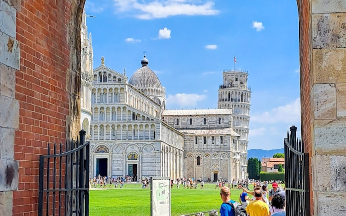 Pisa Cathedral and Leaning Tower viewed through an archway during a guided walking tour.