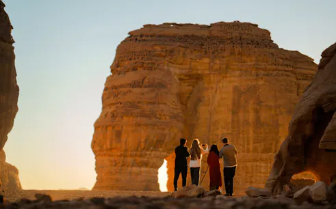 Visitors exploring Hegra rock formations during AlUla day trip from Madinah.