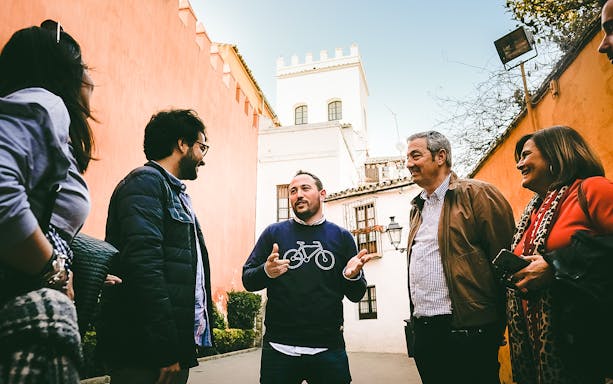 Group of people on a guided tour in the Jewish Quarter, discussing historical landmarks.