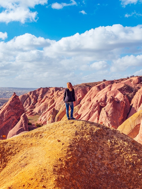 Girl overlooking Red Valley rock formations in Cappadocia, Turkey.