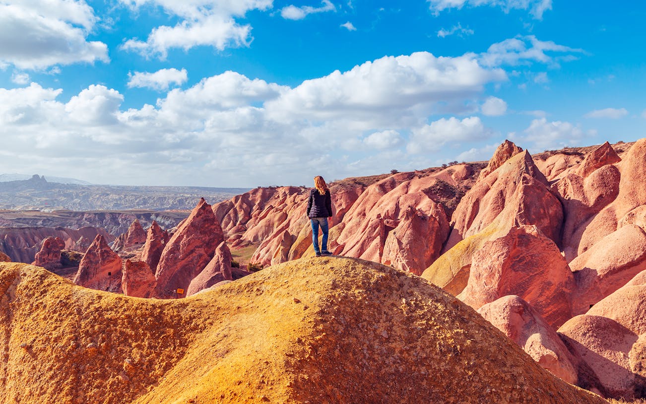 Girl overlooking Red Valley rock formations in Cappadocia, Turkey.
