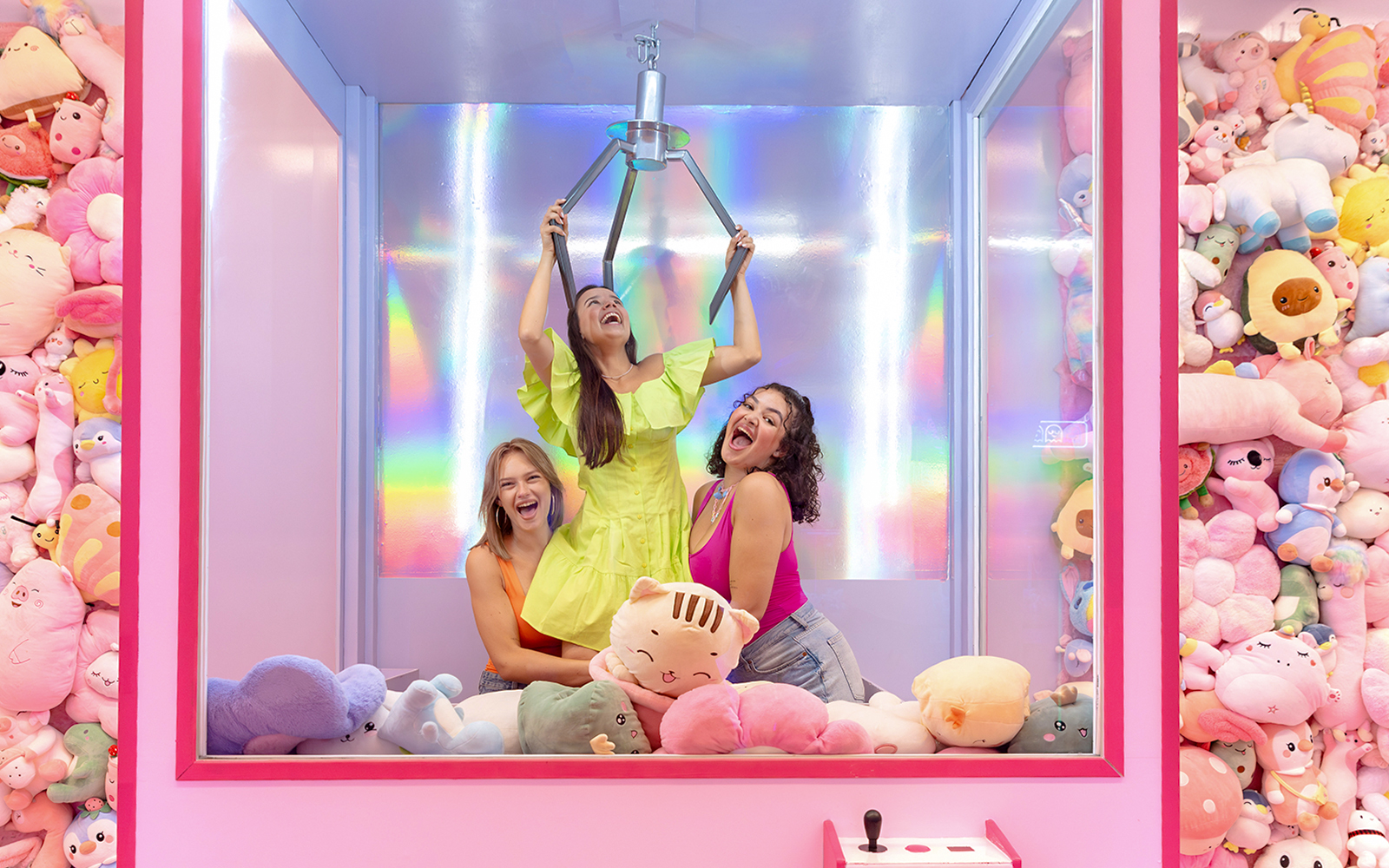 Guests enjoying a claw machine filled with plush toys at WONDR Experience, Amsterdam.