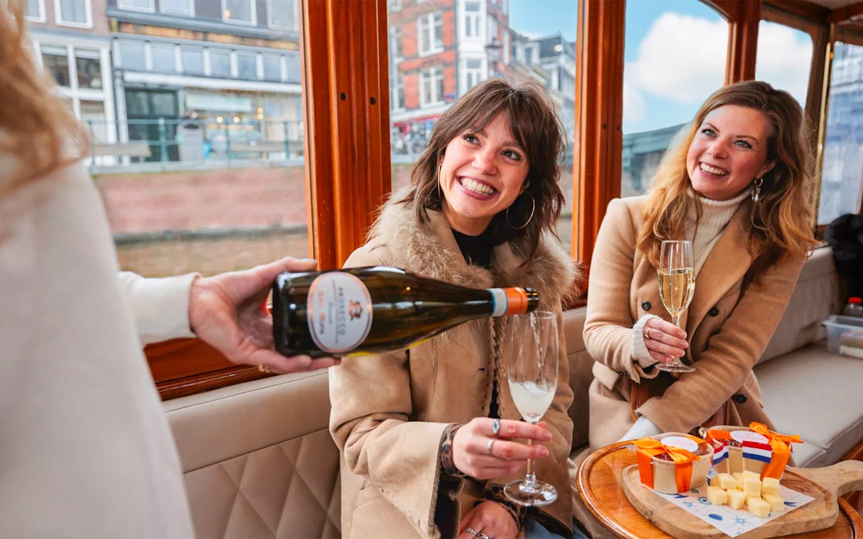 Host pouring drinks for guests on a luxury romantic cruise in Amsterdam.