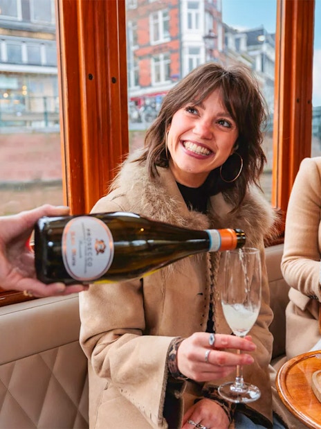 Host pouring drinks for guests on a luxury romantic cruise in Amsterdam.