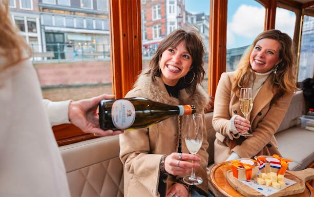 Host pouring drinks for guests on a luxury romantic cruise in Amsterdam.
