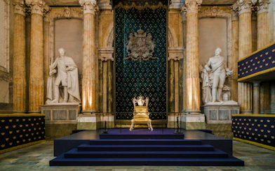 Throne room interior at Stockholm Royal Palace with ornate golden throne.