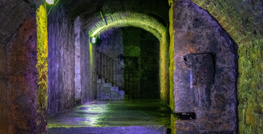 Edinburgh Vaults stone corridor with dim lighting and arched ceilings.