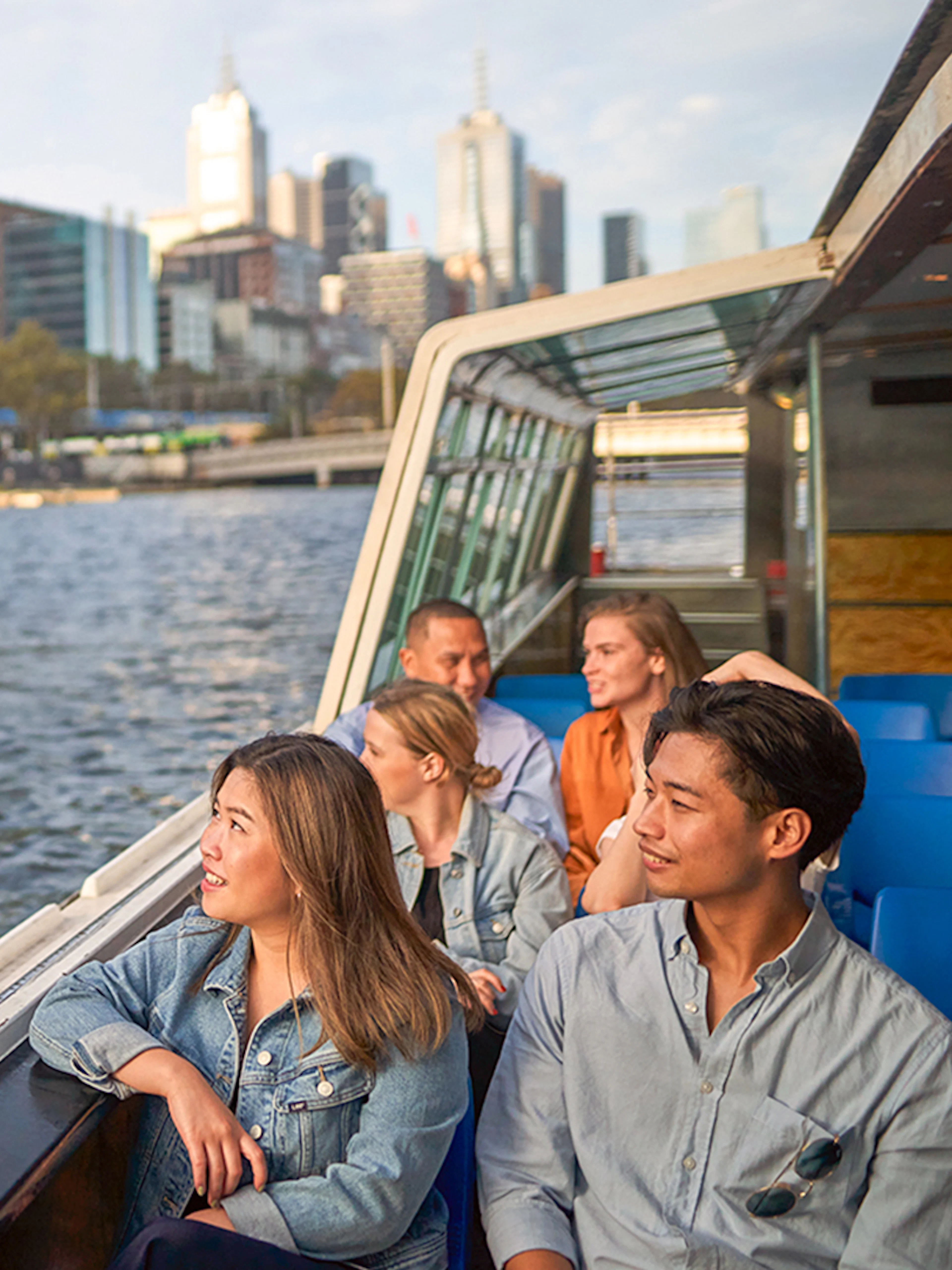 Guests enjoying the Melbourne River Cruise with city skyline views.