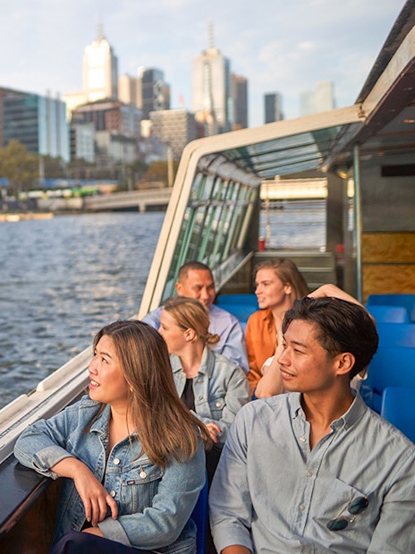 Guests enjoying the Melbourne River Cruise with city skyline views.