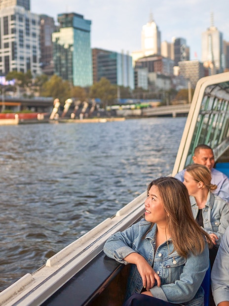 Guests enjoying the Melbourne River Cruise with city skyline views.