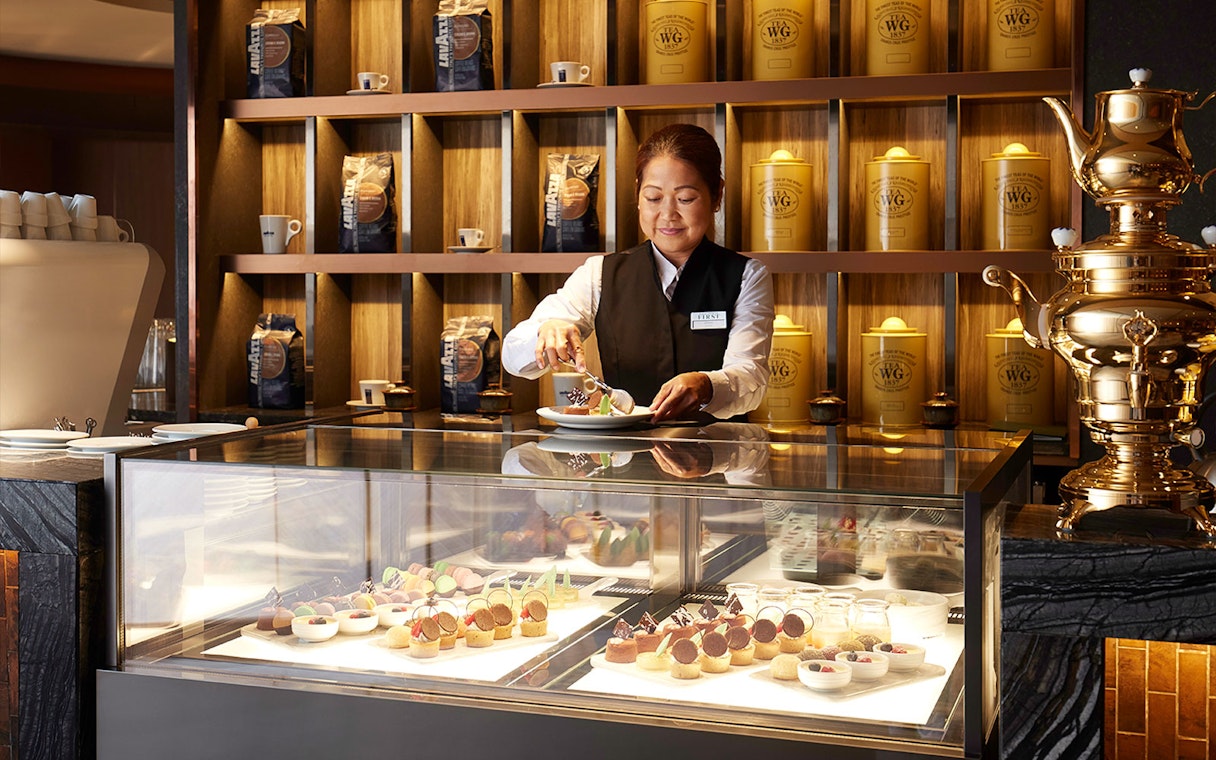 Server preparing desserts in the first-class lounge at Hong Kong International Airport.