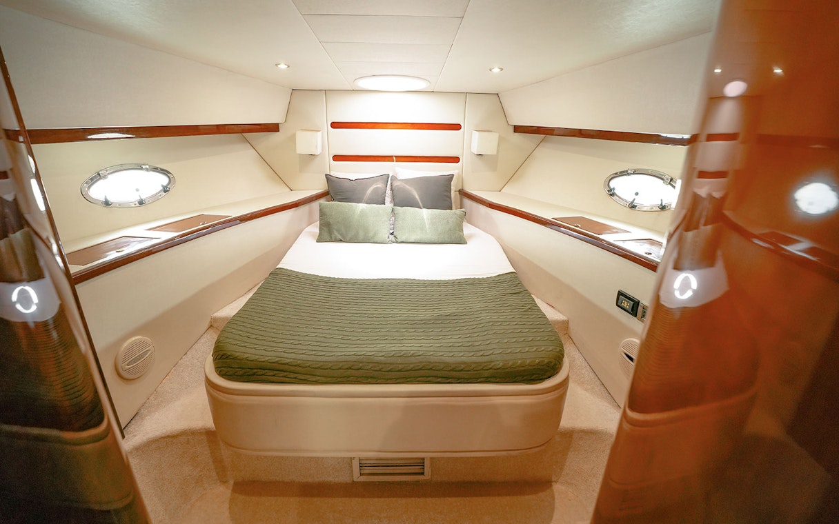 Luxury yacht bedroom with green bedding, Dubai.