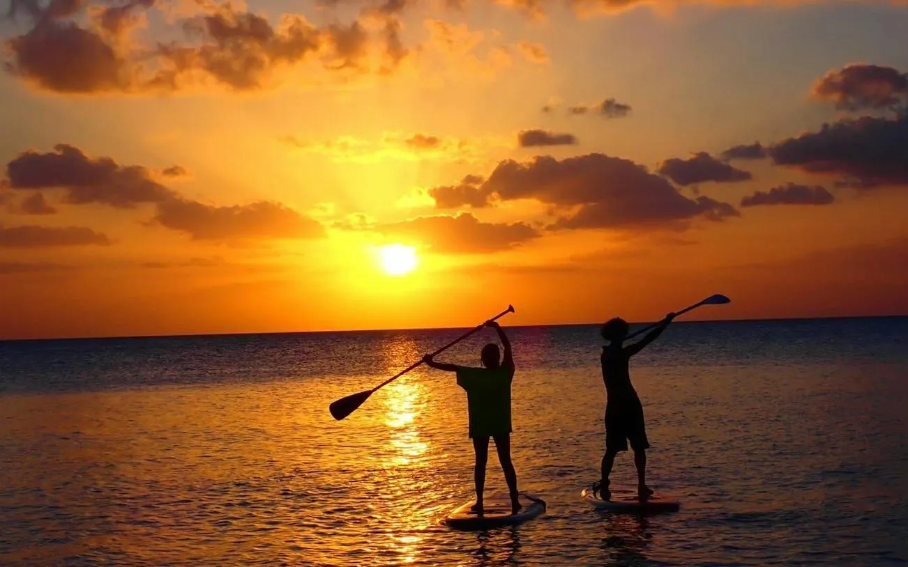 Paddleboarders at sunset on Miyakojima, Okinawa during SUP tour.