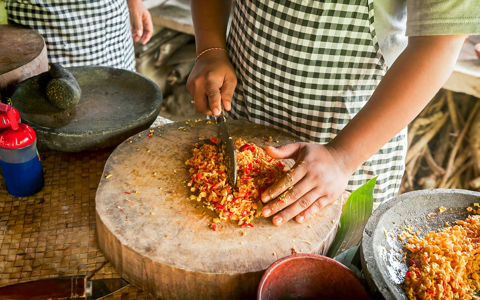 Bali cooking class participants prepare traditional dishes in a kitchen.