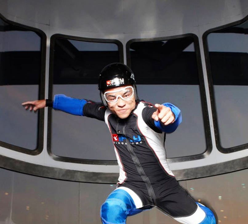 Indoor skydiving experience at iFly Singapore with a view of Sentosa Island.
