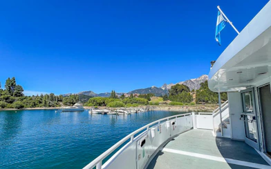 Boat cruising on Nahuel Huapi Lake with mountains and shoreline in view.