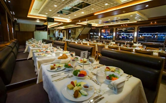 Dining setup on a Bosphorus dinner cruise with tables set for a Turkish night show in Istanbul.