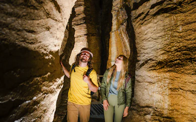 Tourists exploring Te Anau Glowworm Caves with rock formations.