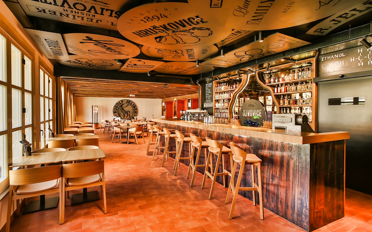 Slivovitz Museum bar area with seating, showcasing bottles and decor for plum brandy tasting experience.