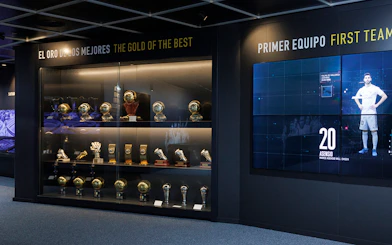 Trophy display at Santiago Bernabéu Stadium museum, featuring football awards and memorabilia.