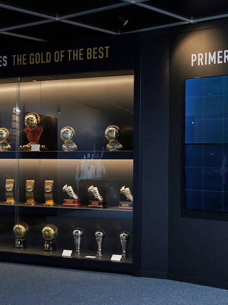 Trophy display at Santiago Bernabéu Stadium museum, featuring football awards and memorabilia.