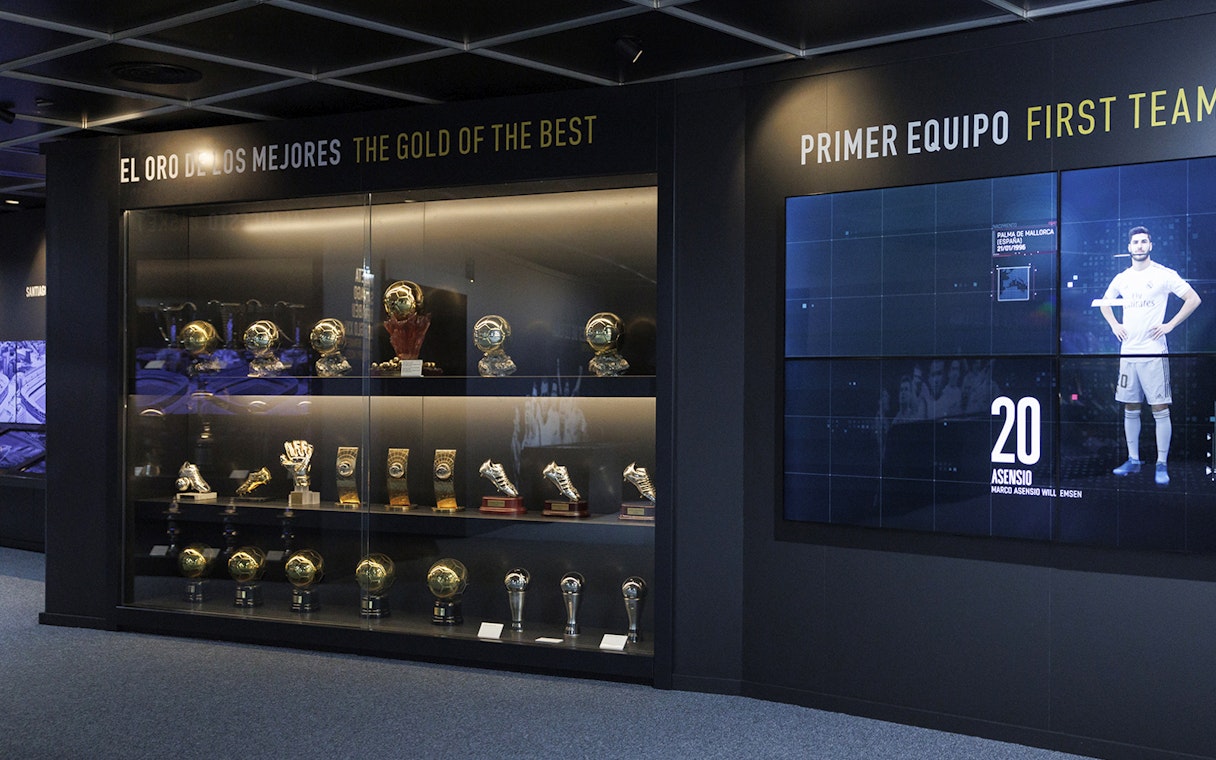 Trophy display at Santiago Bernabéu Stadium museum, featuring football awards and memorabilia.