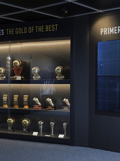 Trophy display at Santiago Bernabéu Stadium museum, featuring football awards and memorabilia.