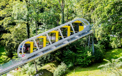 Hungerburgbahn funicular ascending through lush forest in Innsbruck, Austria.