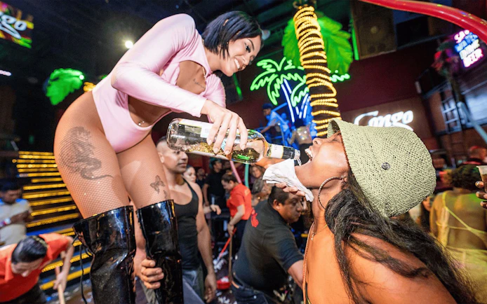 Performer pouring drink into guest's mouth at Coco Bongo Congo Bar.
