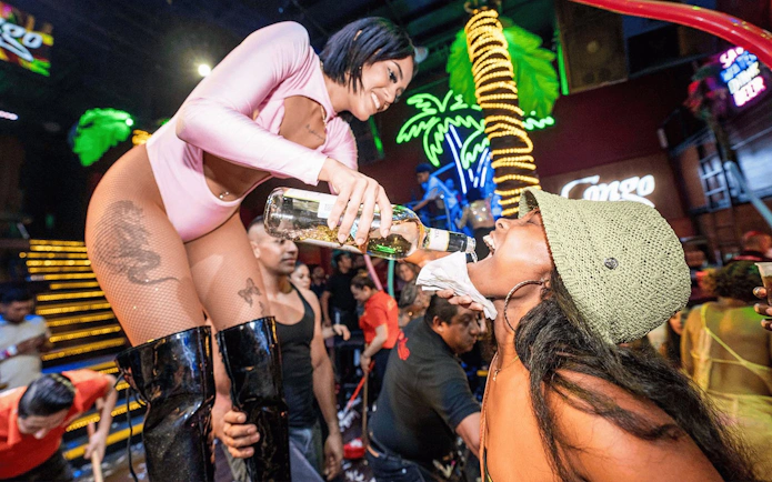 Performer pouring drink into guest's mouth at Coco Bongo Congo Bar.