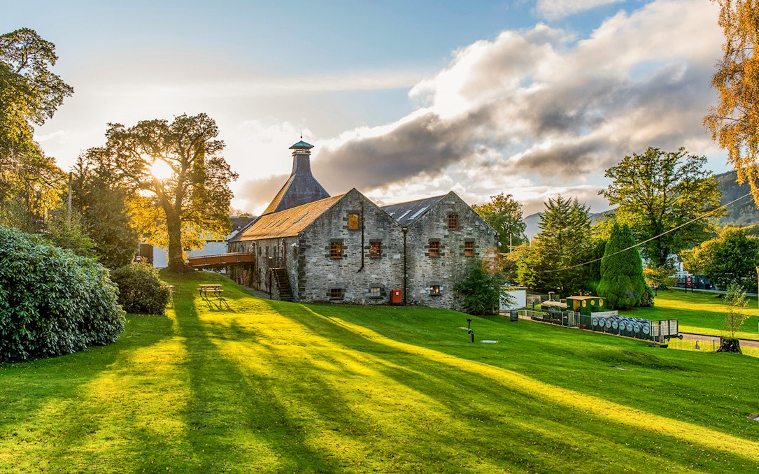 Whisky distillery in a scenic landscape near Edinburgh, part of the Ultimate Whisky Experience tour.