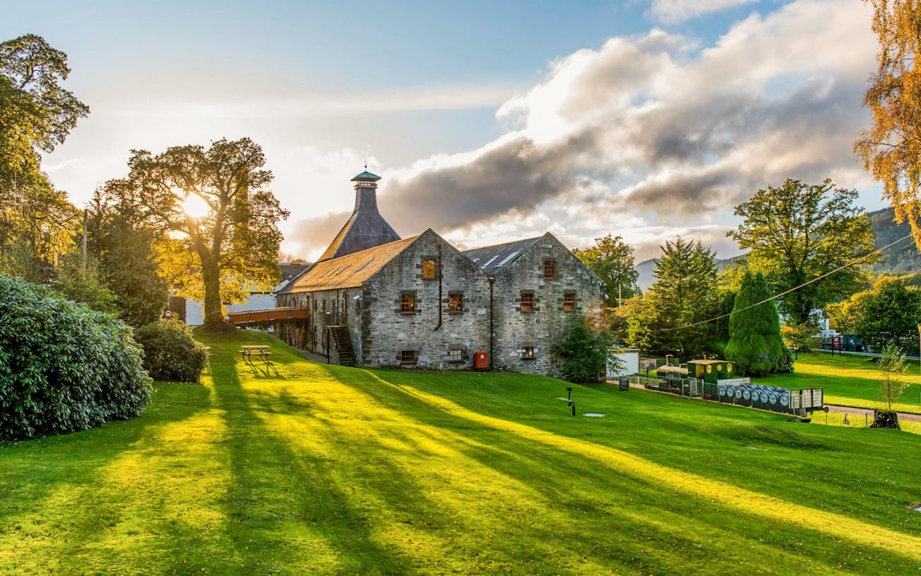 Whisky distillery in a scenic landscape near Edinburgh, part of the Ultimate Whisky Experience tour.