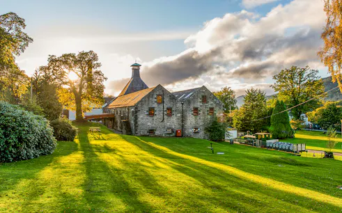 Whisky distillery in a scenic landscape near Edinburgh, part of the Ultimate Whisky Experience tour.
