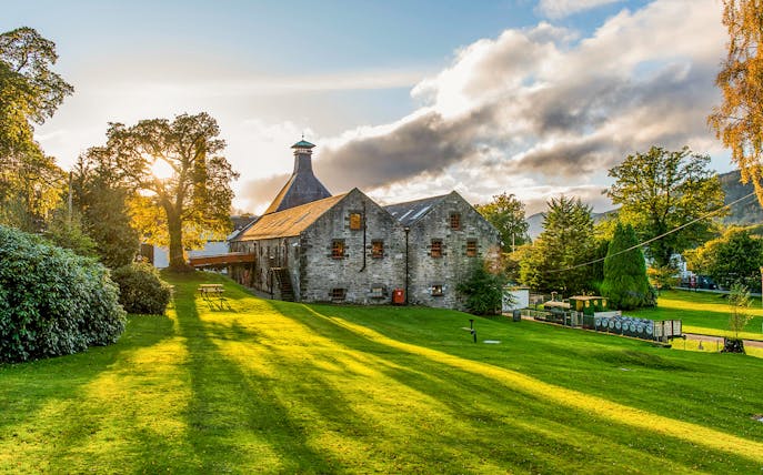 Whisky distillery in a scenic landscape near Edinburgh, part of the Ultimate Whisky Experience tour.