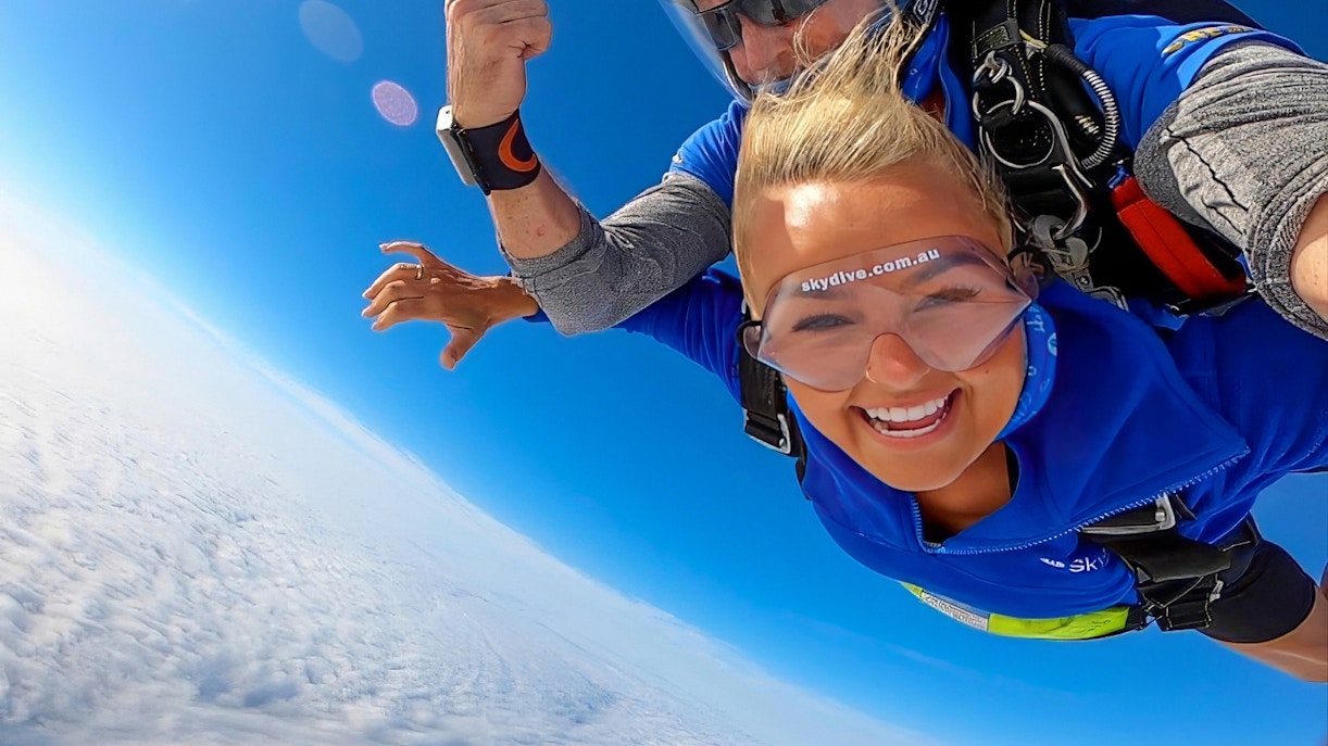 Woman and instructor tandem skydiving in Newcastle, Australia