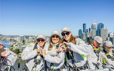 Participants on the Story Bridge Adventure Climb in Brisbane with city skyline in the background.