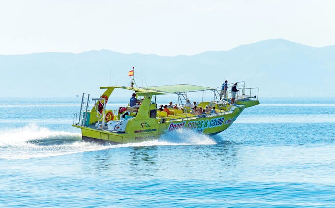 Boat with tourists on Alcudia's coast during a 3-hour caves and snorkel trip.
