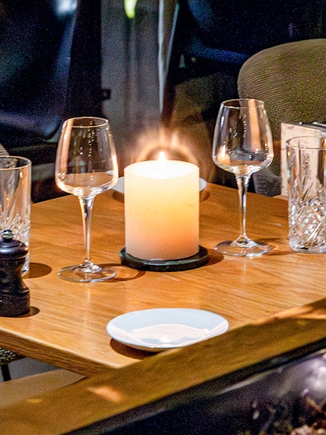Dining table set with glassware and candle at Flora Danica, Champs Elysées, Paris.
