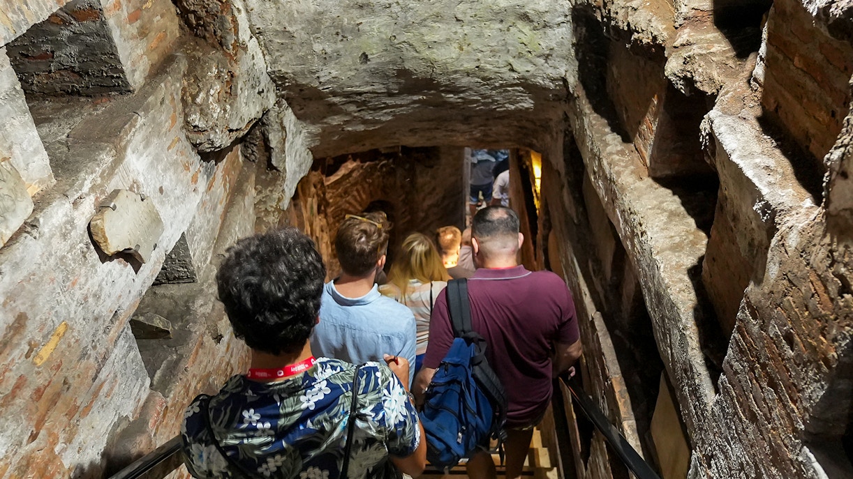 Visitors with guide entering Capuchin Crypt in Rome's historic catacombs.