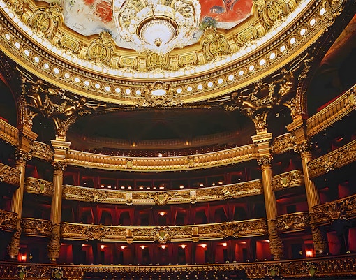 Palais Garnier interior with ornate chandeliers and grand staircase, Paris, France.