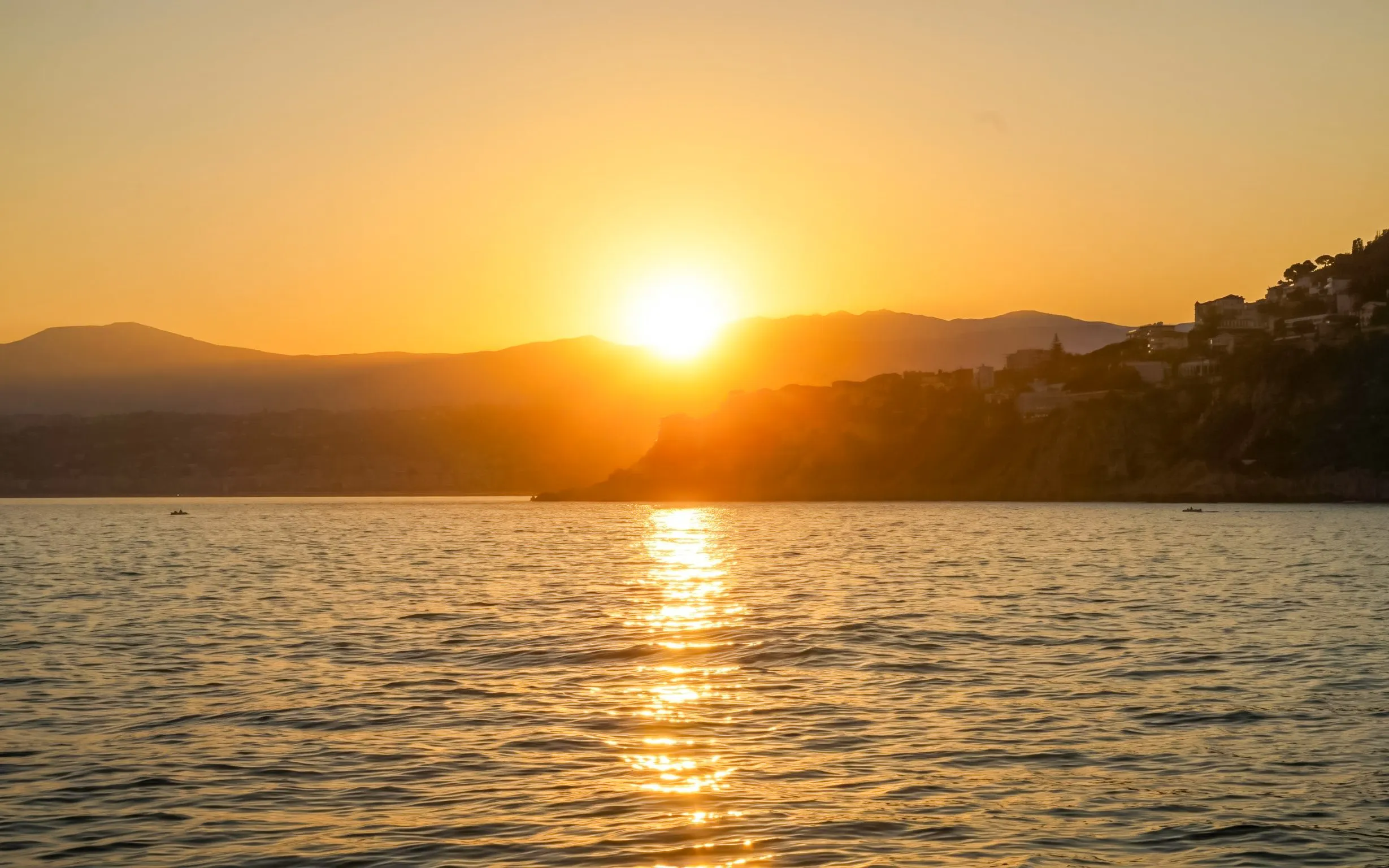 Sunset over the sea with Villefranche coastline in the background.
