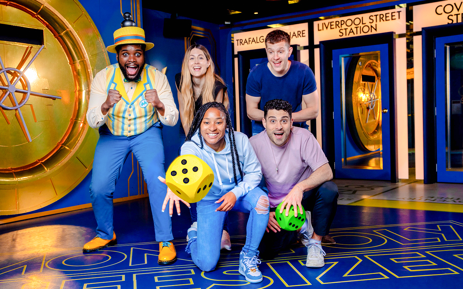 Guests playing a life-sized Monopoly game in London, interacting with oversized game pieces.