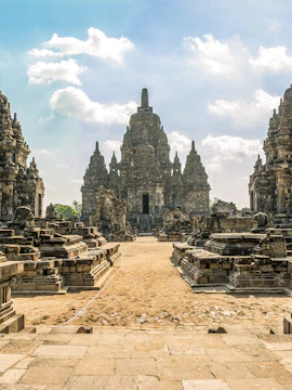 Prambanan Temple complex with ancient stone structures under a blue sky in Yogyakarta, Indonesia.